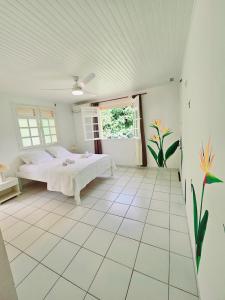 a bedroom with a bed in a white room at Exceptional villa KODEÏA - private spa & panoramic view in Sainte-Marie