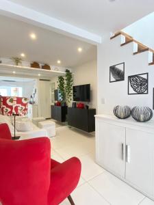 a living room with a red chair and a couch at MATER Vila Borges in Rio de Janeiro