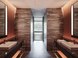 a bathroom with two sinks and two mirrors at Ananti at Busan Village in Busan