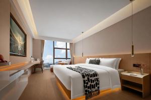 a hotel room with a large bed and a desk at Surprise Hotel Chengdu in Chengdu