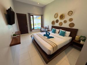 a bedroom with a large bed with a blue animal on it at Wish Uluwatu in Uluwatu +22 photos