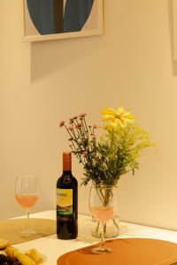 a bottle of wine and a vase of flowers on a table at ABC Stay in Seoul +67 photos