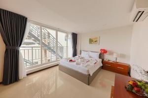 a bedroom with a bed and a large window at Sea Light Hotel Nha Trang Beach in Nha Trang +48 photos