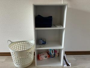 a white shelf with a basket in a room at アルピエe207号室 軽自動車のみ敷地内無料駐車場Wi-Fi付き in Kumamoto
