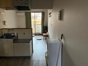 a kitchen with a sink and a refrigerator at アルピエe207号室 軽自動車のみ敷地内無料駐車場Wi-Fi付き in Kumamoto