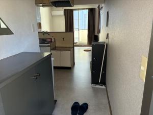 a kitchen with two pairs of shoes on the floor at アルピエd 201号室 軽自動車無料駐車場Wi-Fiあります お部屋リフォーム済み in Kumamoto