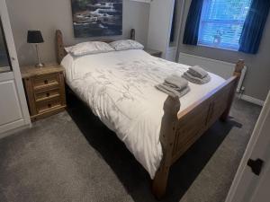 a bedroom with a bed with towels on it at Honeysuckle Cottage in Richmond