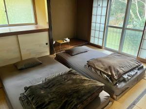 two beds sitting in a room with windows at Cruise garden in Kanō
