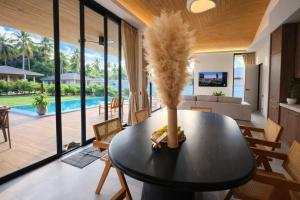 a living room with a table with a vase on it at AVA Radharani Villa in Wok Tum