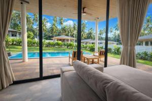 a living room with a couch and a view of a pool at AVA Radharani Villa in Wok Tum