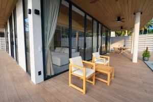a patio with a table and chairs on a house at AVA Radharani Villa in Wok Tum