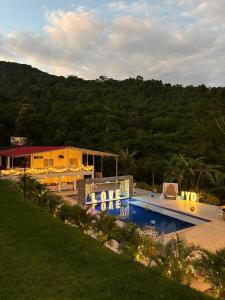 a house with a swimming pool next to a mountain at Finca Villa Carmen, Vía Magdalena in Villeta +49 photos