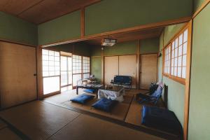 an empty room with a table and chairs and windows at 柿畑の宿 Private stay with farm and house all to yourself in Katsuragi