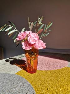 a vase filled with pink flowers sitting on a table at Studio indépendant de 2 à 4 personnes in La Biolle