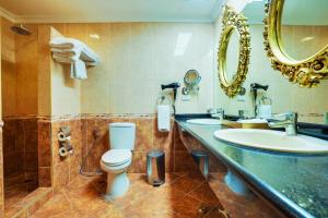 a bathroom with a toilet and a sink and a mirror at ABC Entertainment Resort in Angeles