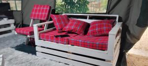 a bed with red plaid pillows on it at Destiny Paradise in Amagoro