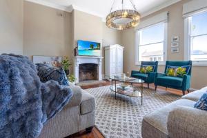 a living room with two couches and a fireplace at Fox House Scone - Apartments in Scone