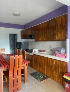 a kitchen with wooden cabinets and a table with chairs at Harmony Mines in Baguio