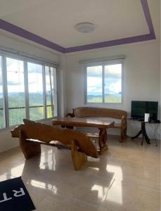 a living room with wooden benches and windows at Harmony Mines in Baguio
