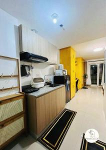 a kitchen with wooden cabinets and a counter top at Bernwood Tower IloIlo - Heavens Crib in Iloilo City
