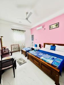 a bedroom with two beds and a pink wall at Messiah Royal Residence in Negombo