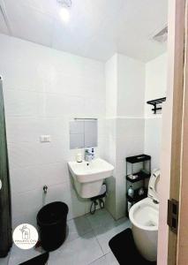 a white bathroom with a sink and a toilet at Bernwood Tower IloIlo - Heavens Crib in Iloilo City +2 photos