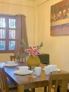 a wooden table with plates and bowls and a vase at Uong Oasis in San Salvador +17 photos