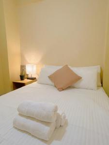 a white bed with towels on top of it at Uong Oasis in San Salvador