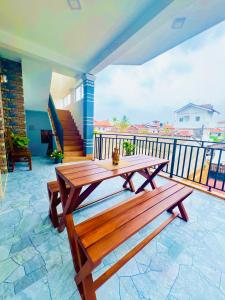 a wooden picnic table on a patio with a balcony at Messiah Royal Residence in Negombo