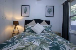 a bedroom with a bed with a green and white comforter at Buninyong Golfside Getaway in Buninyong