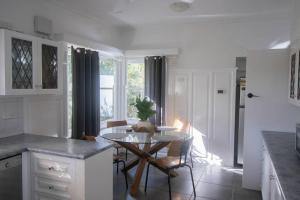 a kitchen with a table and chairs in a room at Buninyong Golfside Getaway in Buninyong