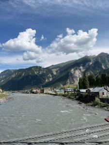 a view of a river with mountains in the background at Sea Green Guest House in Srinagar