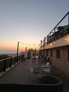 a balcony with chairs and a sunset in the background at Chalets in Arez - Adagio in Al Arz