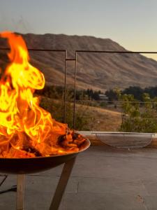 a fire pit on a patio with a view of a mountain at Chalets in Arez - Adagio in Al Arz