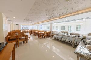 a large dining room with tables and chairs and windows at Sea Light Hotel Nha Trang Beach in Nha Trang