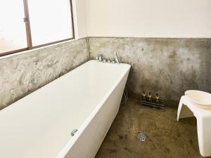 une salle de bains avec baignoire et toilettes dans l'établissement villa Like hiroshima 愛犬と泊まれる一棟貸し, à Mihara