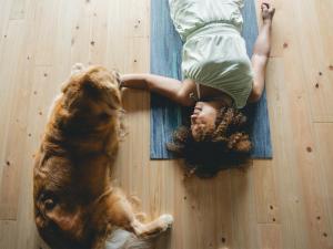 un homme allongé par terre à côté d'un chien dans l'établissement villa Like hiroshima 愛犬と泊まれる一棟貸し, à Mihara