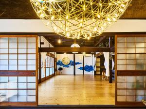 un grand lustre dans une pièce avec un parquet dans l'établissement villa Like hiroshima 愛犬と泊まれる一棟貸し, à Mihara 37 autres photos