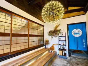 une pièce avec un banc et un lustre dans l'établissement villa Like hiroshima 愛犬と泊まれる一棟貸し, à Mihara