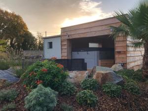 a garage with a white door and some plants at Natur eau Bulle in Ploufragan