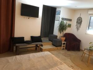 a living room with a couch and a tv on the wall at Natur eau Bulle in Ploufragan