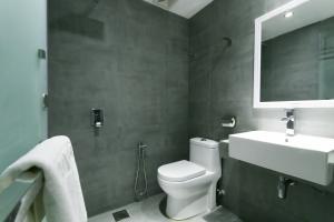 a bathroom with a toilet and a sink and a mirror at Hotel 99 Botanik Klang in Klang
