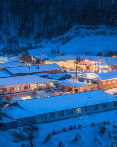 a group of buildings covered in snow at night at Snow Valley Ma Hua Inn in Wuchang