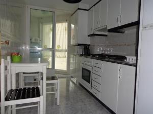 ミヤドイロにあるApartamento Cereixosのキッチン(白い家電製品、白いカウンタートップ付)