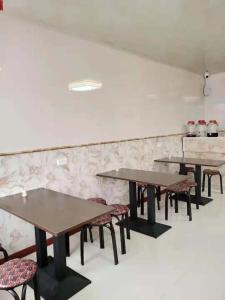 a row of tables and chairs in a room at Snow Valley Ma Hua Inn in Wuchang