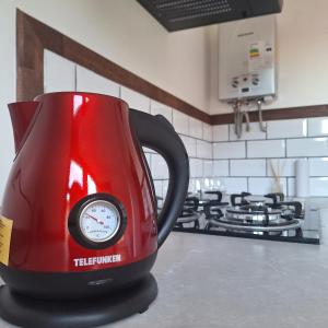 a red tea kettle sitting on top of a kitchen counter at Cabaña Roquin Patagonia in Chile Chico