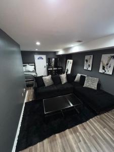 a living room with a black couch and a bed at Comfortstayrus in Orange