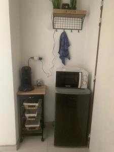a kitchen with a microwave and a small refrigerator at O kAZ de Petite île in Petite Île
