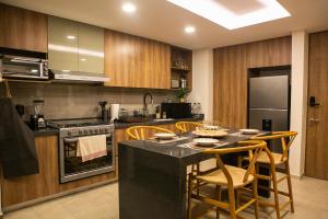 a kitchen with wooden cabinets and a table with chairs at Premium Apartment - Terraza Premium, Pool & Gym in Querétaro