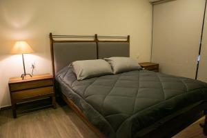 a bedroom with a bed and a lamp on a night stand at Premium Apartment - Terraza Premium, Pool & Gym in Querétaro +59 photos